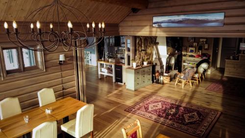 a dining room and living room with a chandelier at Storestølen Fjellhotell in Hovet