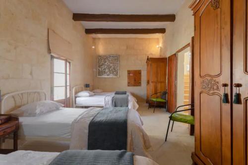 um quarto com três camas num quarto em Ta' Frenc Farmhouse em Gharb