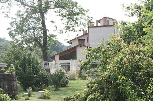 une maison au milieu d'une cour arborée dans l'établissement Il Baco Da Seta, à Manta