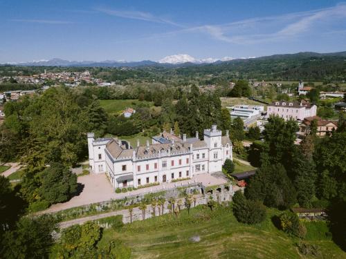 una vista aerea di una grande casa bianca con alberi di Castello Dal Pozzo a Oleggio Castello