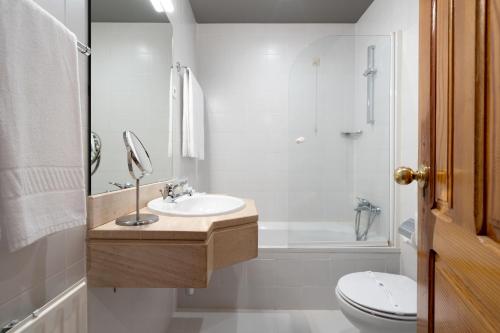 un bagno con lavandino, WC e vasca di Hotel Carvalho Araujo a Geres