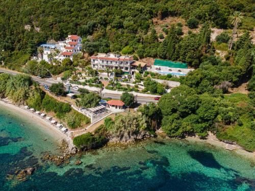 an aerial view of a house on a hill next to the ocean at Aurora Beach Hotel in Agios Ioannis Peristeron