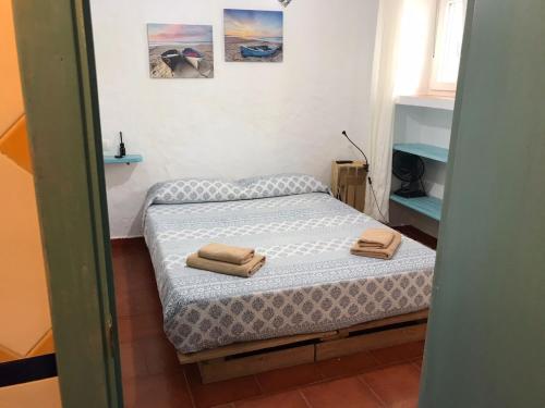 1 dormitorio con 1 cama con 2 toallas en DUPLEX TARIFEÑO in the OLD TOWN, en Tarifa