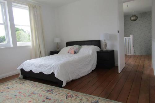 a bedroom with a large bed and a wooden floor at Lovely 3 Bed House Close to Carlyon Bay Beach! in Carlyon Bay