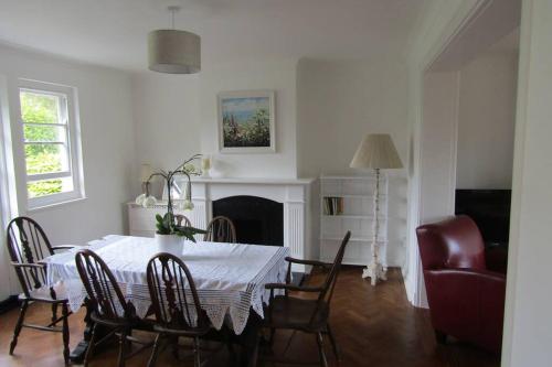 a dining table and chairs in a living room at Lovely 3 Bed House Close to Carlyon Bay Beach! in Carlyon Bay