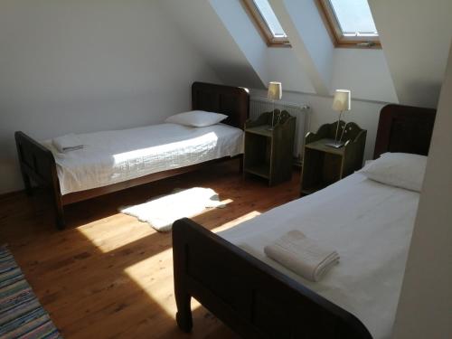 a attic bedroom with two beds and a window at Vass Panzio in Zălan