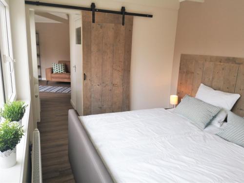 a bedroom with a bed and a sliding barn door at DWC00 - New romantic studio with large terrace in Domburg
