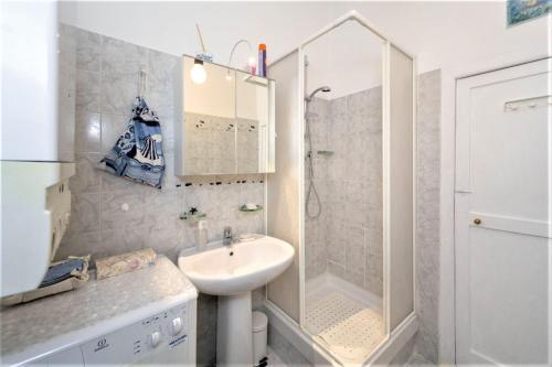 a white bathroom with a sink and a shower at Mysa Properties Appartamento Genova in Genova
