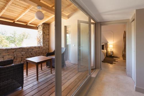 een kamer met een glazen deur naar een slaapkamer bij Mas des Herbes Blanches Hôtel & Spa – Relais & Châteaux in Joucas