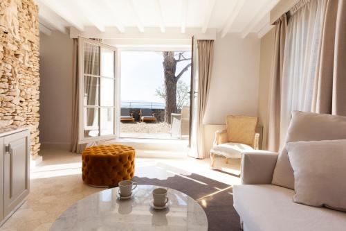 a living room with a white couch and a glass table at Mas des Herbes Blanches Hôtel & Spa – Relais & Châteaux in Joucas