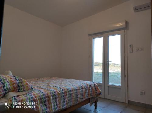 une chambre avec un lit et une porte coulissante en verre dans l'établissement Casevielle le calme en Provence, à Tulette