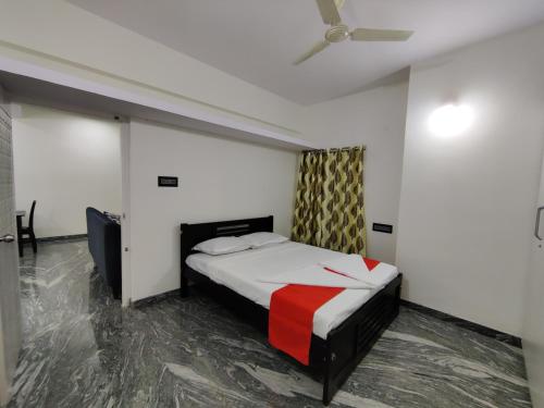 een slaapkamer met een bed en een plafondventilator bij Vogel's Nest in Mysore