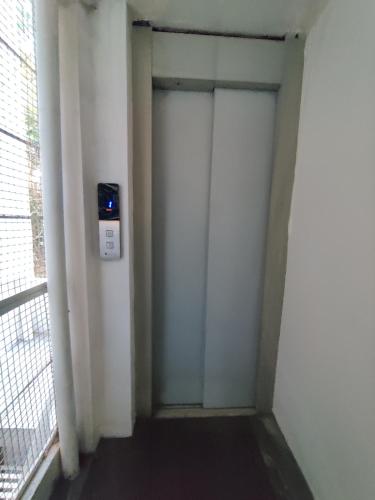 a corridor with two doors in a room with a window at Vogel's Nest in Mysore