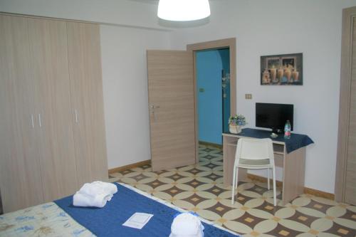 Habitación con cama y escritorio con ordenador. en Villa Del Mare, en Campomarino
