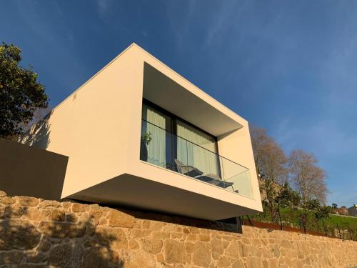 a house with a large window on top of a stone wall at Portovella Lodges & Bungalows in Pala
