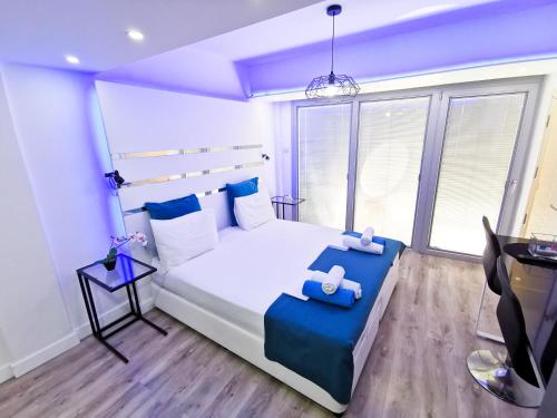 a bedroom with a large white bed with blue accents at Mariandry Apartments in Larnaka