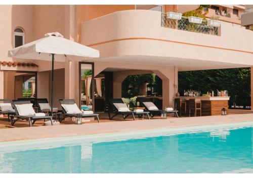 a pool with chairs and an umbrella next to a building at Blue Note Resort & Club in Athens