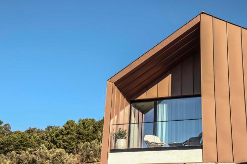 a house with large windows on the side of it at Portovella Lodges & Bungalows in Pala