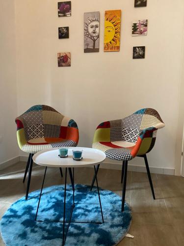two chairs and a table in a room at Nenetta Rooms & Suites Monopoli in Monopoli