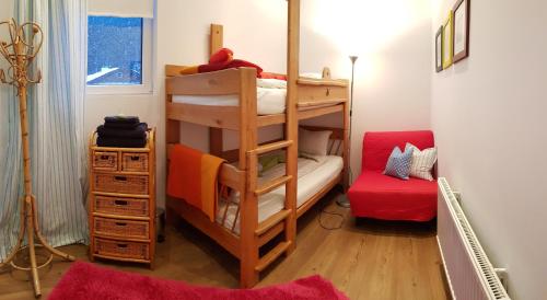 a room with two bunk beds and a red couch at Jagd trifft Moderne & Boutique Jardin Ferienhaus in Annaberg im Lammertal