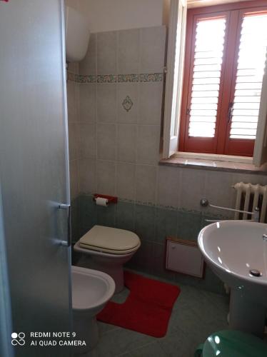 a bathroom with a toilet and a sink at La Numaba in Corato
