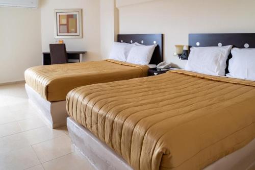 Dos camas en una habitación de hotel contigua en Hotel Plaza del Sol, en Hermosillo
