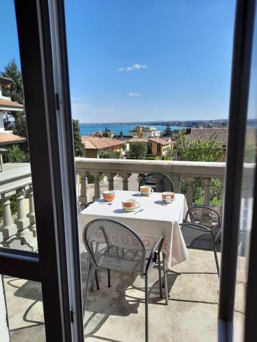 a table on a balcony with a view of the ocean at Appartamenti Esmera in Desenzano del Garda