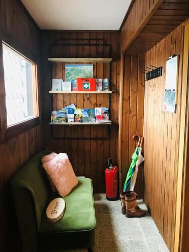 a small room with a green couch and an umbrella at Landhaus Zirben in Bad Kleinkirchheim