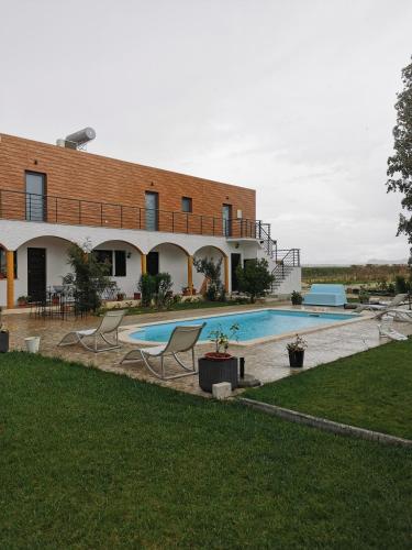 a house with a swimming pool in front of it at Casa das Portas in Azinhaga