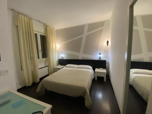 a hotel room with two beds and a mirror at Hotel Angi in Fossò