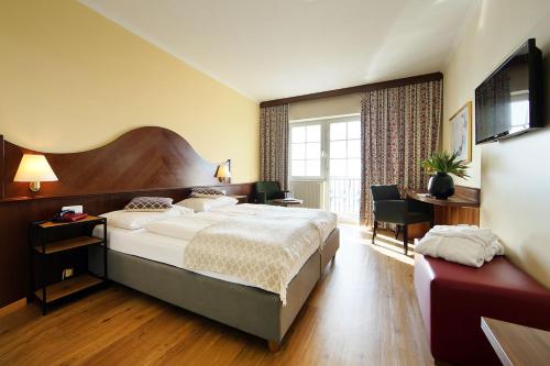 una camera d'albergo con un grande letto e una scrivania di Hotel Rose a Maria Taferl