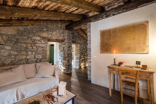 ein Wohnzimmer mit einem Sofa und einem Tisch in der Unterkunft Country House La Bursch in Campiglia Cervo