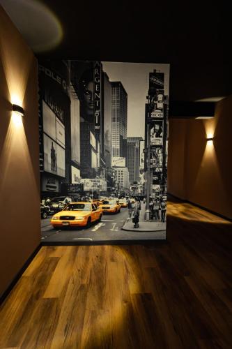 a room with a painting of a city street with taxis at 24Seven Hotel Schwabach in Schwabach