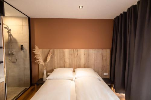 a bedroom with a large bed and a shower at 24Seven Hotel Schwabach in Schwabach