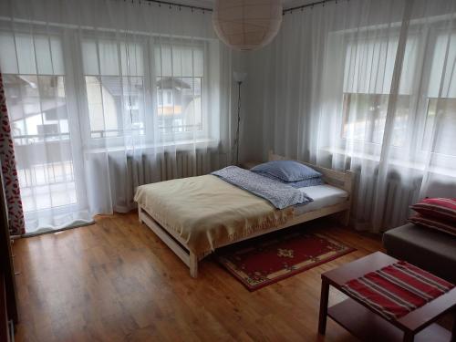 um pequeno quarto com uma cama e janelas em Mieszkanie u Zofii - Krościenko n.D em Krościenko