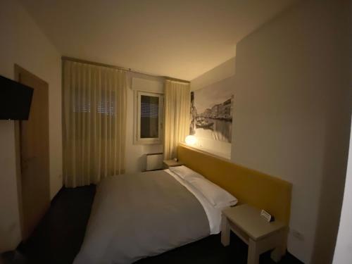a bedroom with a white bed with a window at Hotel Angi in Fossò