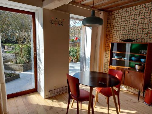 a dining room with a table and two red chairs at La Jauchelle in Thimougies