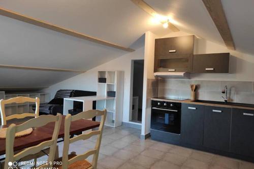 a kitchen and dining room with a table and a stove at Casevielle le haut in Tulette