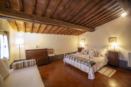 1 dormitorio con cama y techo de madera en Locanda agricola Posapiano, en Montecarlo