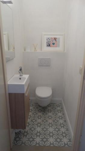 a white bathroom with a toilet and a sink at Vakantieappartment Duplex Aquadelta in Bruinisse