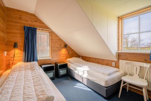 Schlafzimmer im Dachgeschoss mit 2 Betten und einem Fenster in der Unterkunft Annabella 13 in De Koog