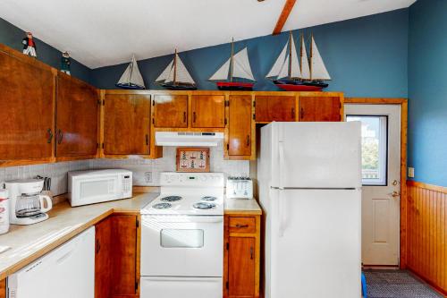 a kitchen with a white refrigerator and sailboats on the wall at Pirate's Lair #7-F in Frisco