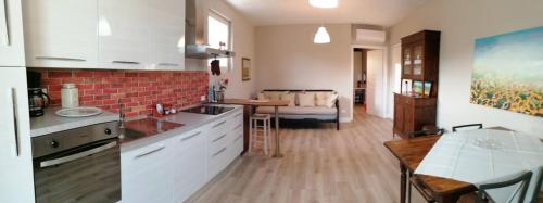 a kitchen and living room with a table and a couch at Bilocale Papavero, Magnolia o Girasole in San Felice del Benaco
