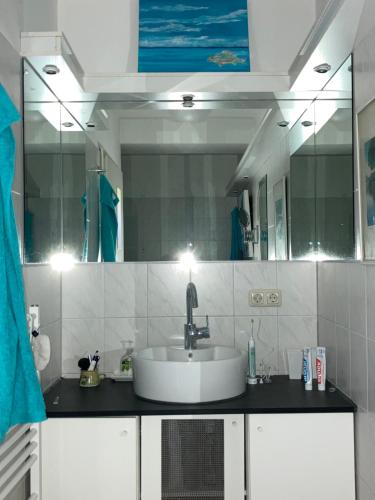 ein Badezimmer mit einem Waschbecken und einem großen Spiegel in der Unterkunft Ich kenne ein Haus am Meer in Putbus