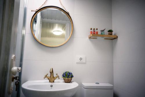 a bathroom with a sink and a mirror on the wall at Casa A Boleriña in Combarro