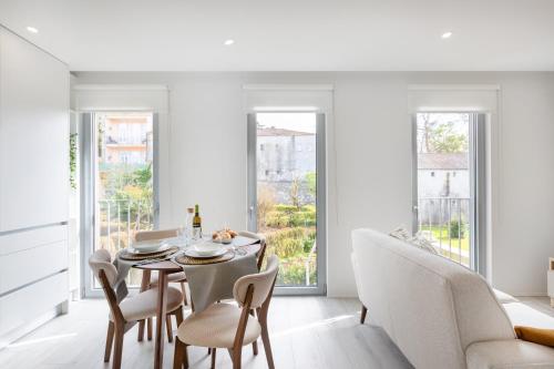 a dining room with a table and chairs and windows at Modern Studio @ Palácio de Cristal in Porto