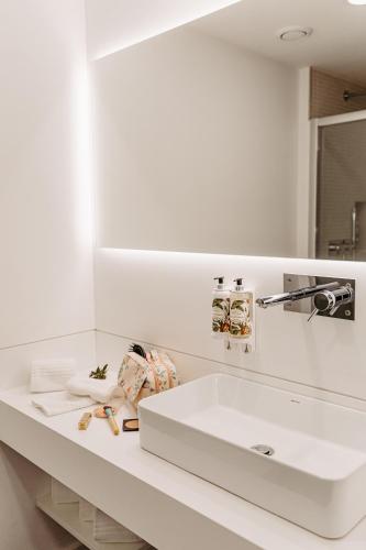 a bathroom with a white sink and a mirror at Canadiano Urban Nature Hotel in Ponta Delgada