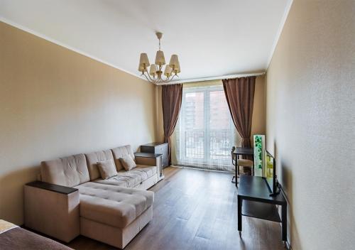 un soggiorno con divano e tavolo di Apartment v novom dome on Kremenchugskaya 13 a San Pietroburgo