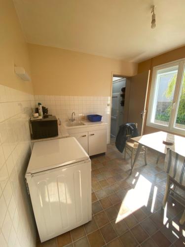 d'une cuisine avec un évier et une table avec une fenêtre. dans l'établissement MON DADA, à Granville