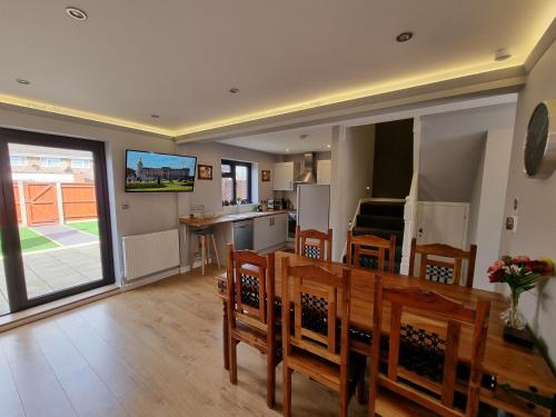 a kitchen and dining room with a table and chairs at Crown Meadow - 4 Bedroom House - Heathrow - ExcellentStays in Colnbrook